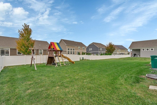 view of yard with a playground, a fenced backyard, and a residential view