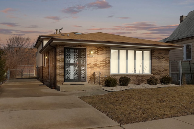 view of front of home featuring a gate, fence, and brick siding