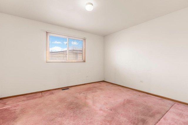 unfurnished room featuring baseboards and light colored carpet