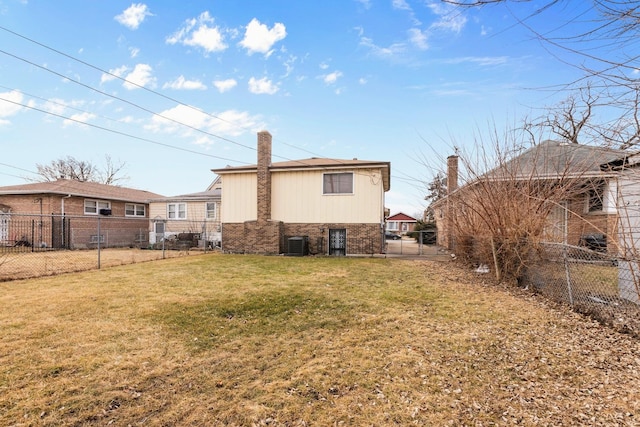 back of property with brick siding, a lawn, central AC unit, and a fenced backyard