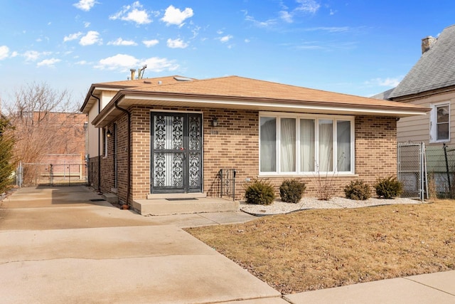 property entrance with brick siding, a shingled roof, fence, and a gate