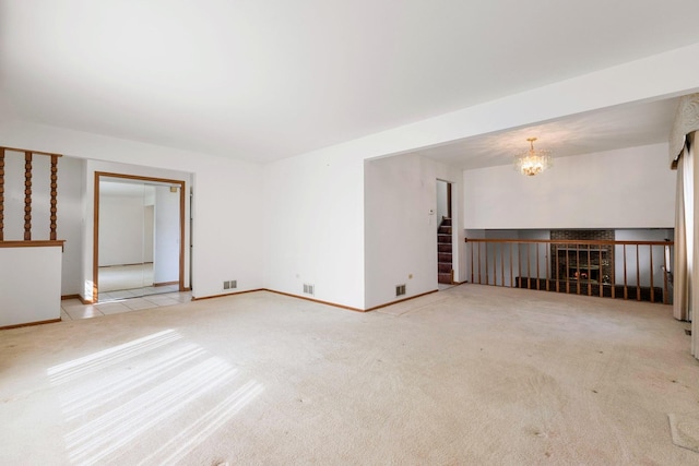 carpeted spare room with visible vents, a notable chandelier, baseboards, and stairs