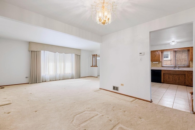 spare room featuring a notable chandelier, visible vents, light carpet, light tile patterned flooring, and baseboards