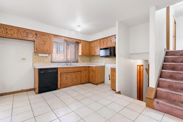 kitchen featuring black appliances, a sink, light countertops, and decorative backsplash