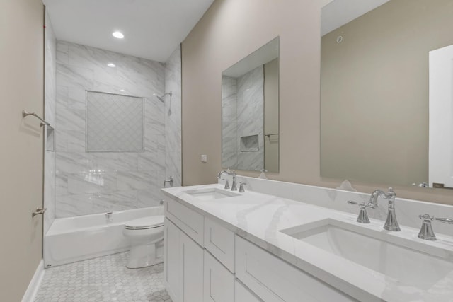 bathroom with double vanity, shower / washtub combination, a sink, and toilet