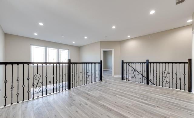 empty room featuring wood finished floors, visible vents, and recessed lighting