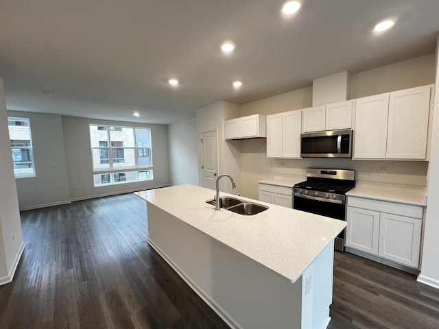 kitchen with appliances with stainless steel finishes, recessed lighting, white cabinetry, and a sink