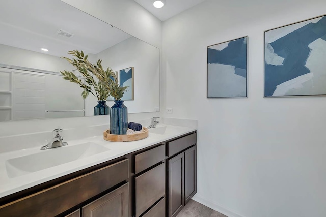 bathroom featuring double vanity, visible vents, a sink, and recessed lighting