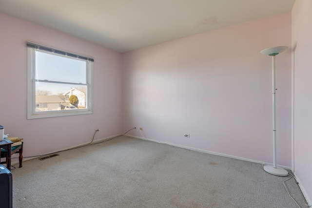 carpeted spare room with visible vents and baseboards