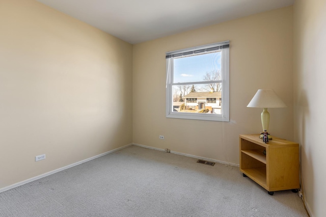 empty room with light carpet, visible vents, and baseboards