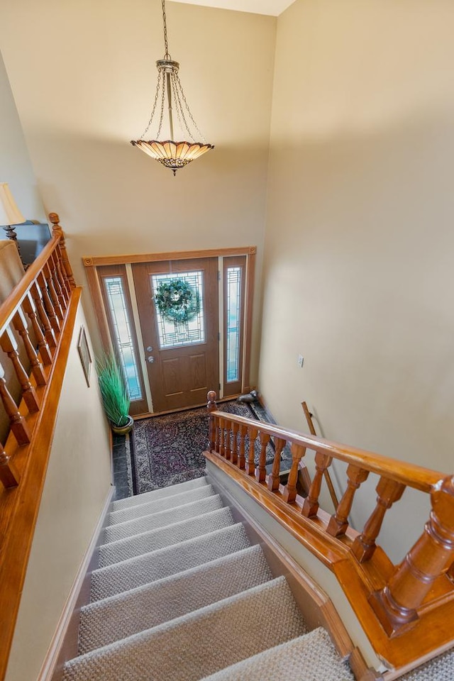 staircase with a high ceiling and baseboards