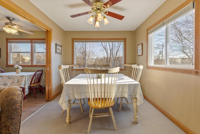 dining space with ceiling fan and baseboards