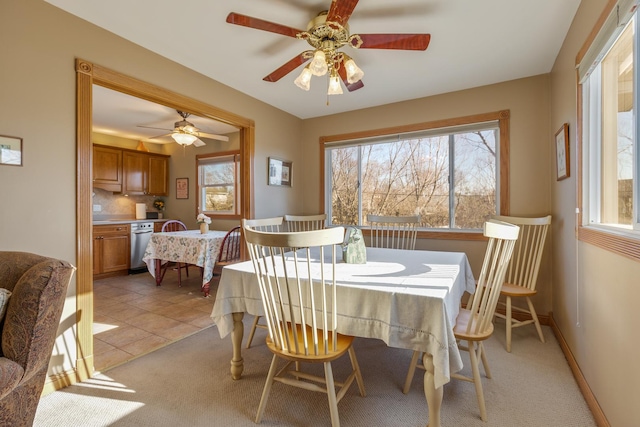 dining room with light tile patterned floors, light carpet, and baseboards