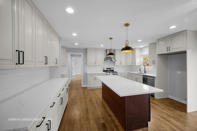 kitchen with stainless steel appliances, wood finished floors, a sink, and light countertops