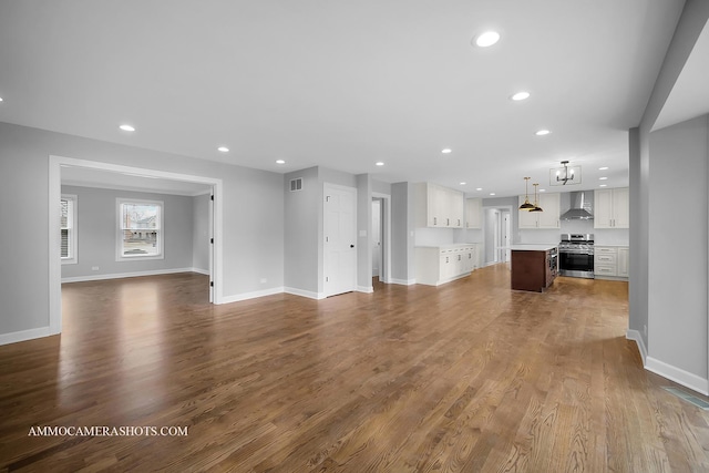 unfurnished living room with baseboards, visible vents, dark wood-type flooring, and recessed lighting