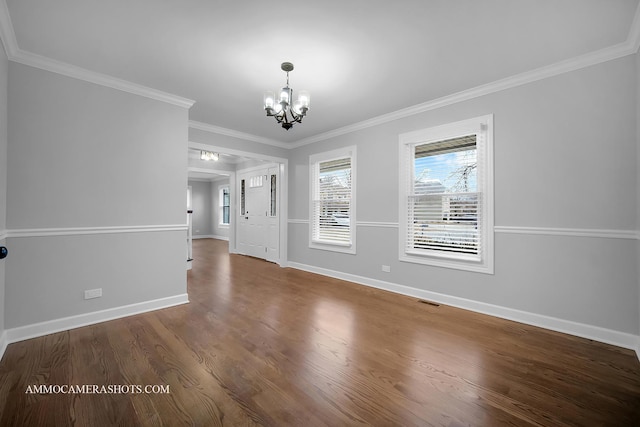 interior space featuring an inviting chandelier, baseboards, ornamental molding, and wood finished floors