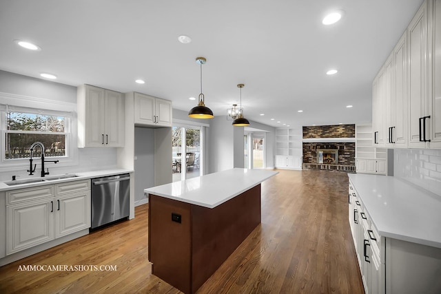 kitchen featuring plenty of natural light, dishwasher, light wood-style flooring, and a sink