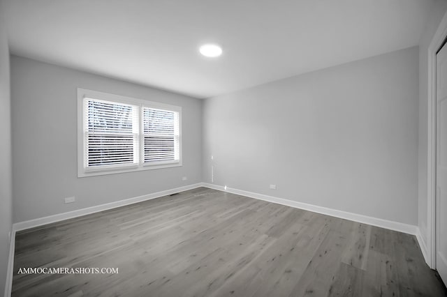 spare room with wood finished floors and baseboards