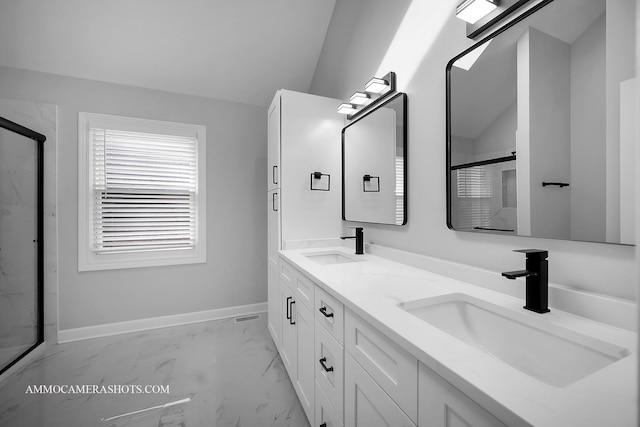 bathroom featuring vaulted ceiling, marble finish floor, a sink, and baseboards