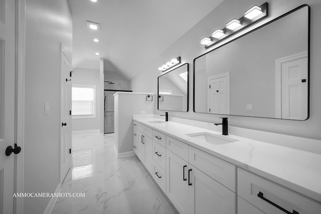 bathroom with lofted ceiling, marble finish floor, double vanity, and a sink