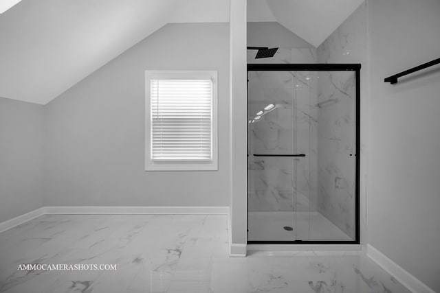 full bath with marble finish floor, a marble finish shower, baseboards, and vaulted ceiling