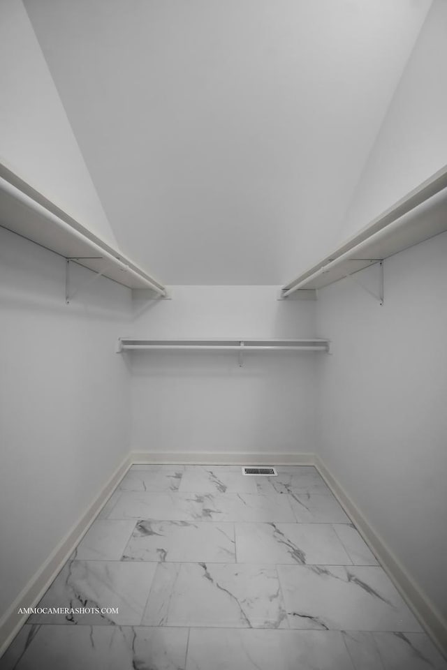 walk in closet featuring marble finish floor and visible vents