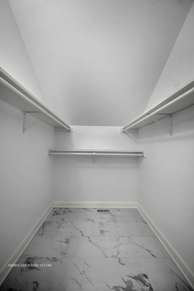 walk in closet with marble finish floor and visible vents