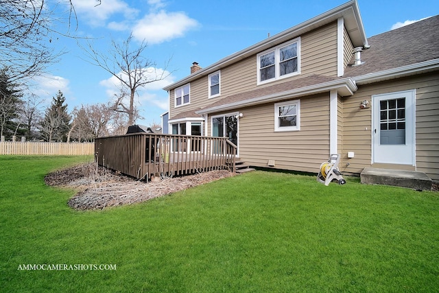 back of property featuring a chimney, a shingled roof, a lawn, fence, and a deck