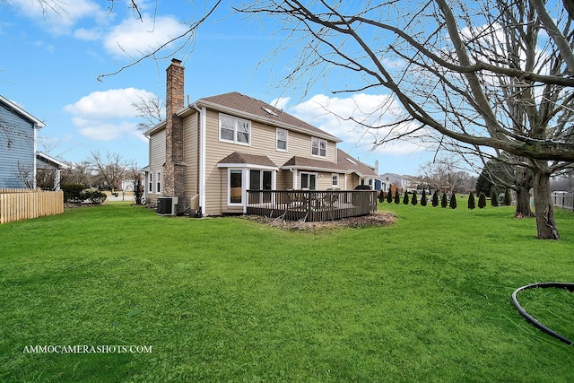 back of property with a yard, a chimney, a wooden deck, and central air condition unit