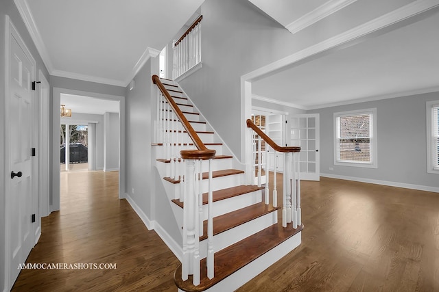 stairway featuring ornamental molding, a wealth of natural light, and wood finished floors