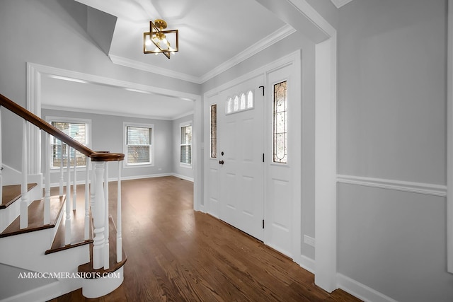 foyer entrance with ornamental molding, stairs, baseboards, and wood finished floors