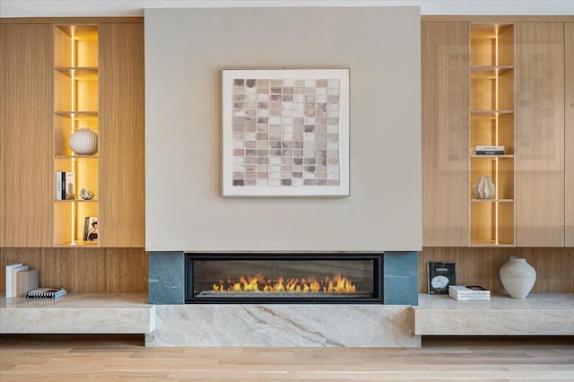 interior details with a glass covered fireplace and wood finished floors