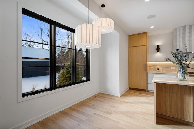 unfurnished dining area featuring light wood-type flooring, baseboards, and recessed lighting