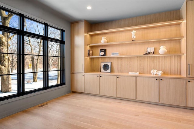 unfurnished room with light wood-style floors, a wealth of natural light, visible vents, and recessed lighting