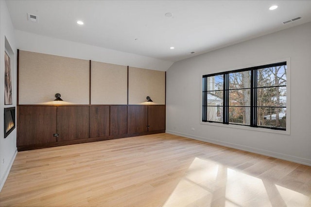 empty room featuring recessed lighting, visible vents, light wood-style flooring, and baseboards