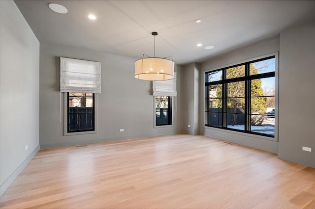 unfurnished dining area with baseboards, light wood-style flooring, and recessed lighting