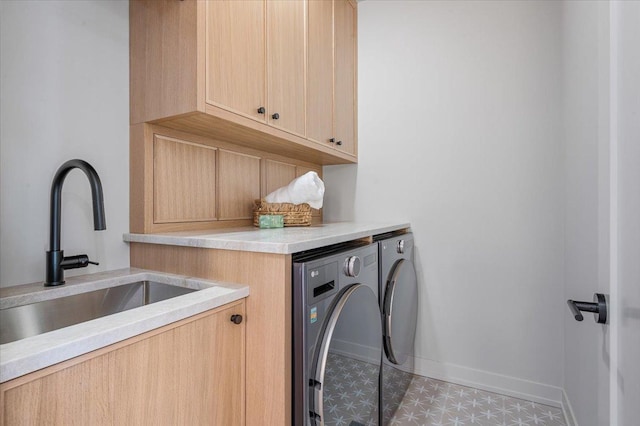 laundry room with independent washer and dryer, a sink, cabinet space, and baseboards