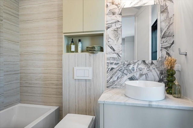 bathroom with a tub, decorative backsplash, tile walls, and vanity