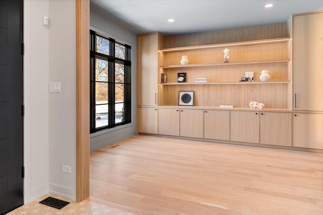 interior space featuring light wood-style floors, visible vents, baseboards, and recessed lighting