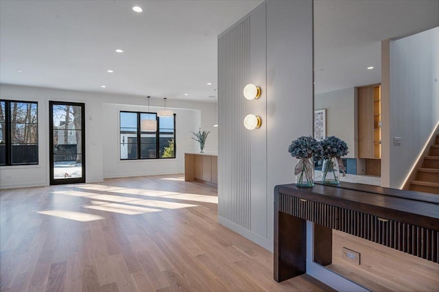 interior space with light wood-style flooring, recessed lighting, stairway, and baseboards