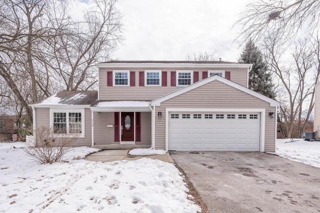 traditional home featuring an attached garage, driveway, and central AC