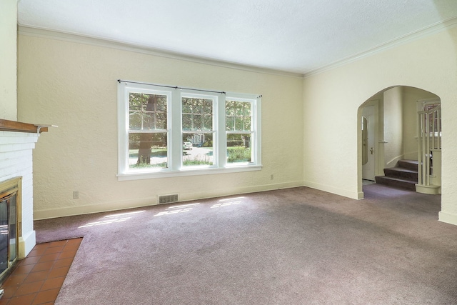 831 W Galena Blvd, Aurora, IL 60506 - unfurnished living room featuring crown molding, arched walkways, a brick fireplace, stairway, and dark carpet