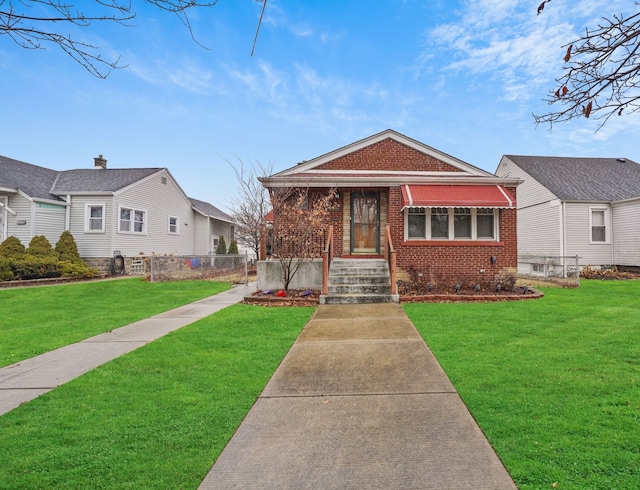 bungalow-style home with fence, a front lawn, and brick siding