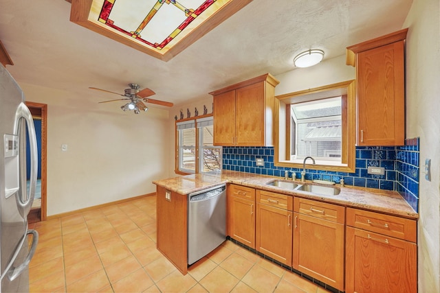 kitchen with appliances with stainless steel finishes, a wealth of natural light, a sink, and a peninsula