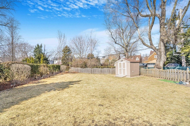 view of yard featuring a storage shed, a fenced backyard, and an outdoor structure