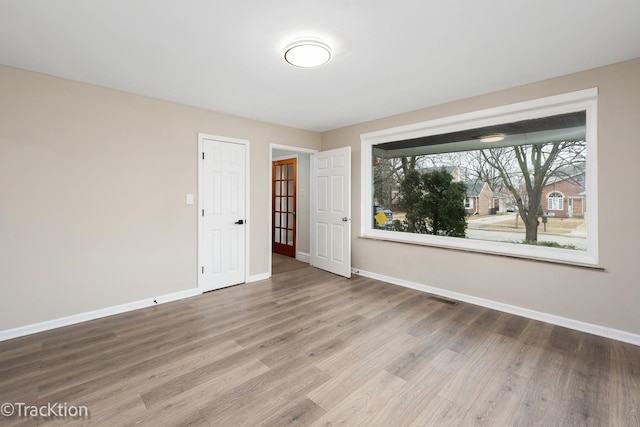 empty room with wood finished floors and baseboards