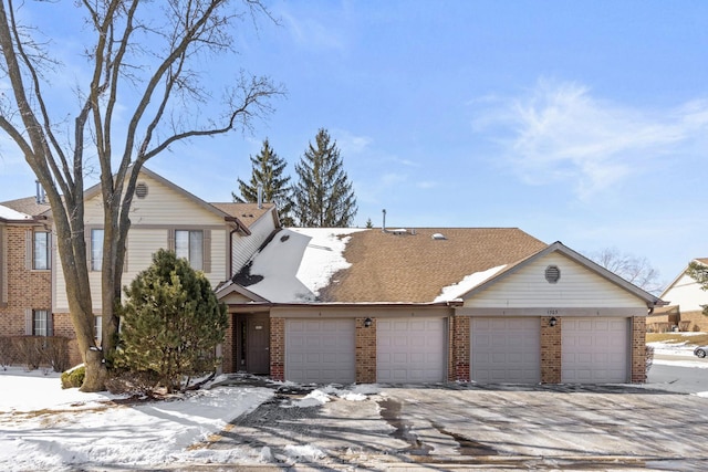 view of front facade with a garage and brick siding