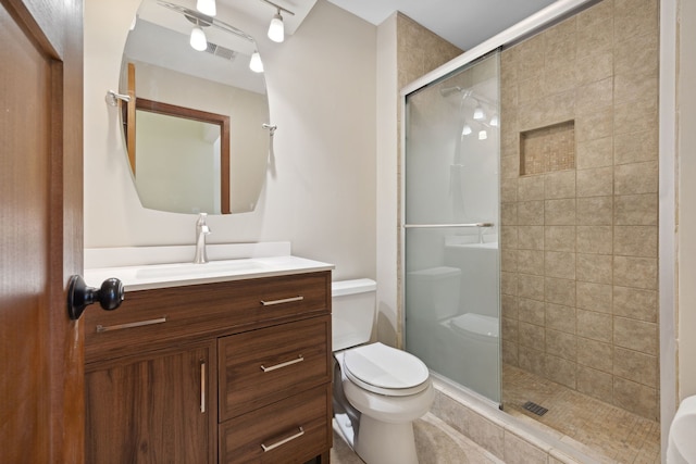 bathroom with toilet, a shower stall, visible vents, and vanity