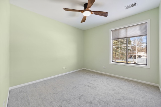 unfurnished room with carpet floors, baseboards, visible vents, and ceiling fan