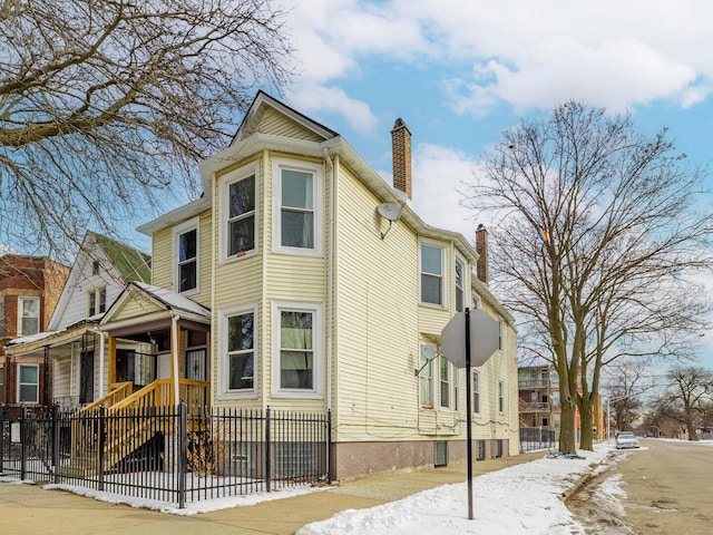 view of front of home featuring fence and a chimney